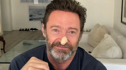 Australian actor Hugh Jackman showing a bandage on his nose after skin cancer surgery