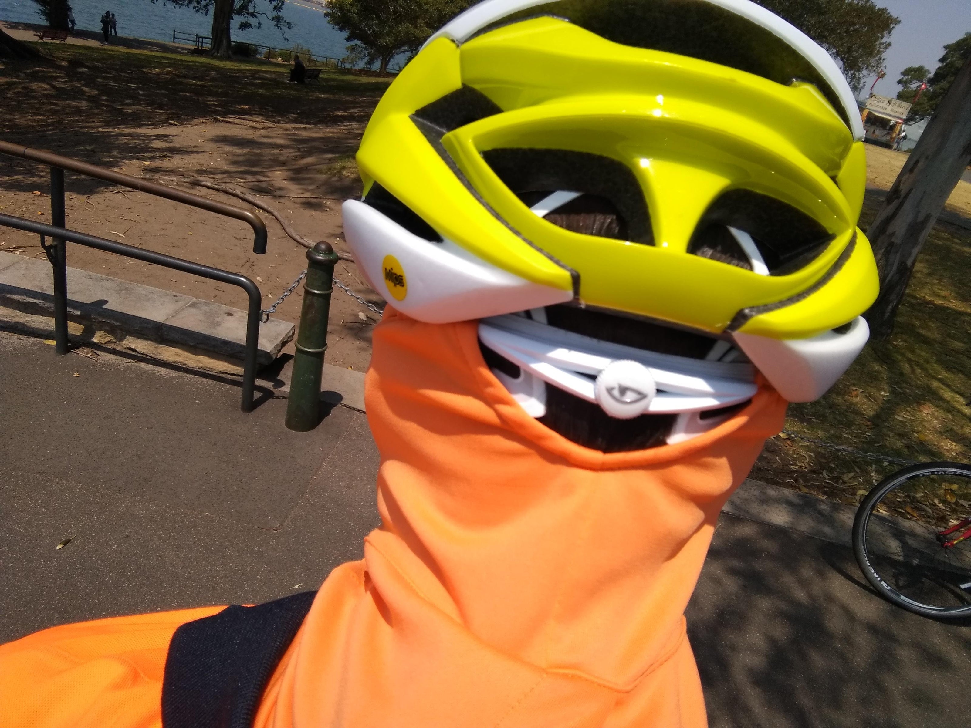 Cyclists wearing UV face mask, showing strap that holds onto helmet. Outback Mask